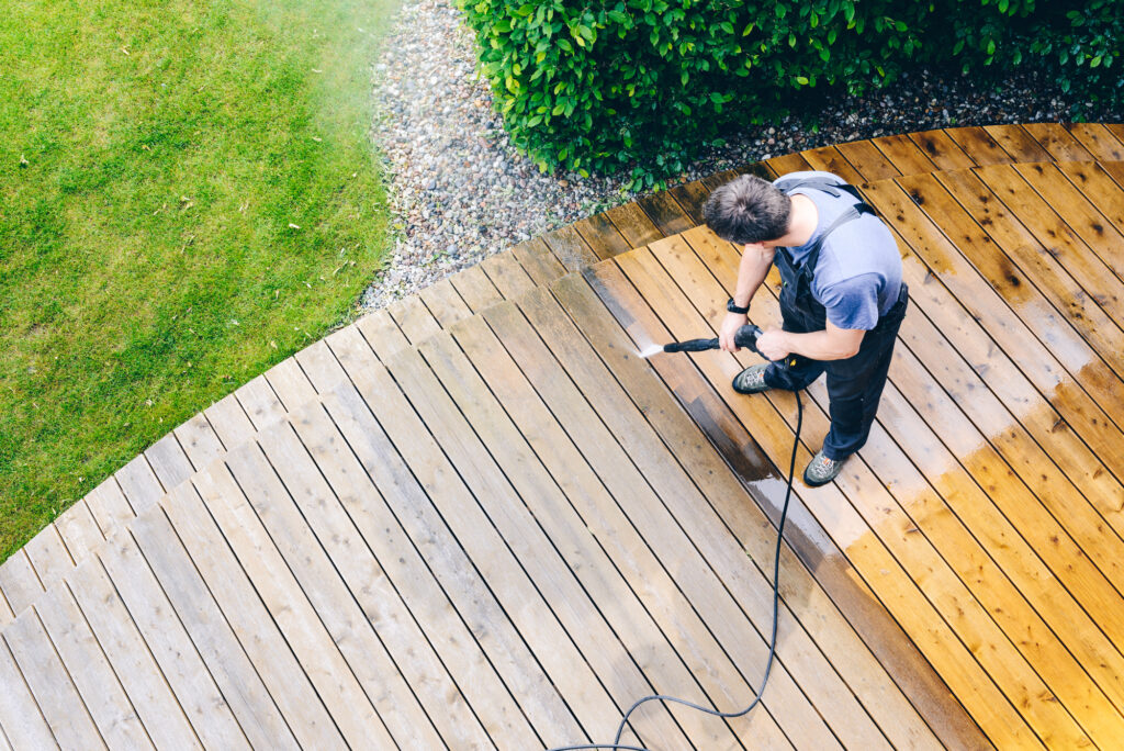 Man cleaning terrace with a power washer